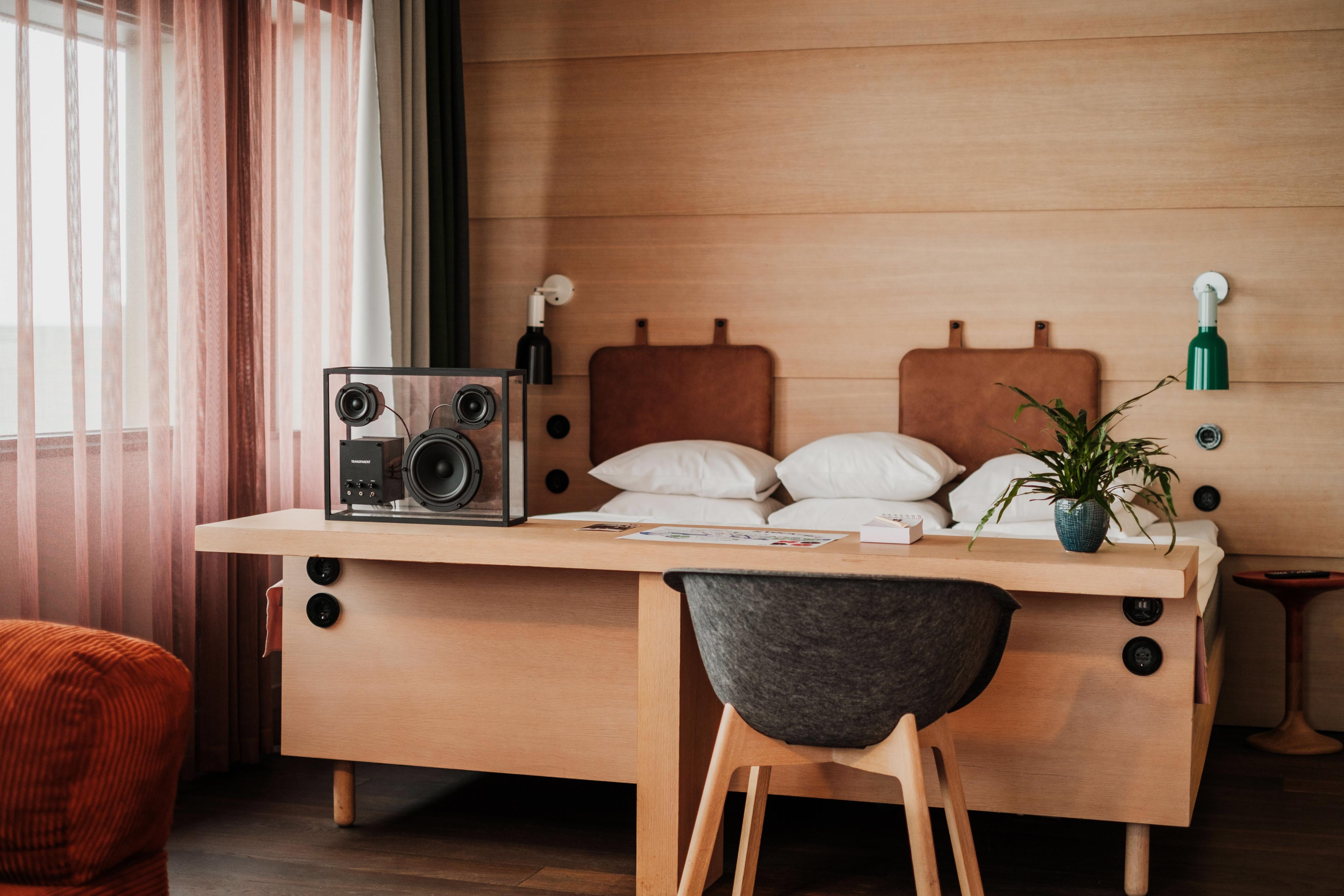 Svit på Hotel Hobo i Stockholm med king size-säng, rymlig lounge-del, skrivbord i ljust trä och designhögtalare.