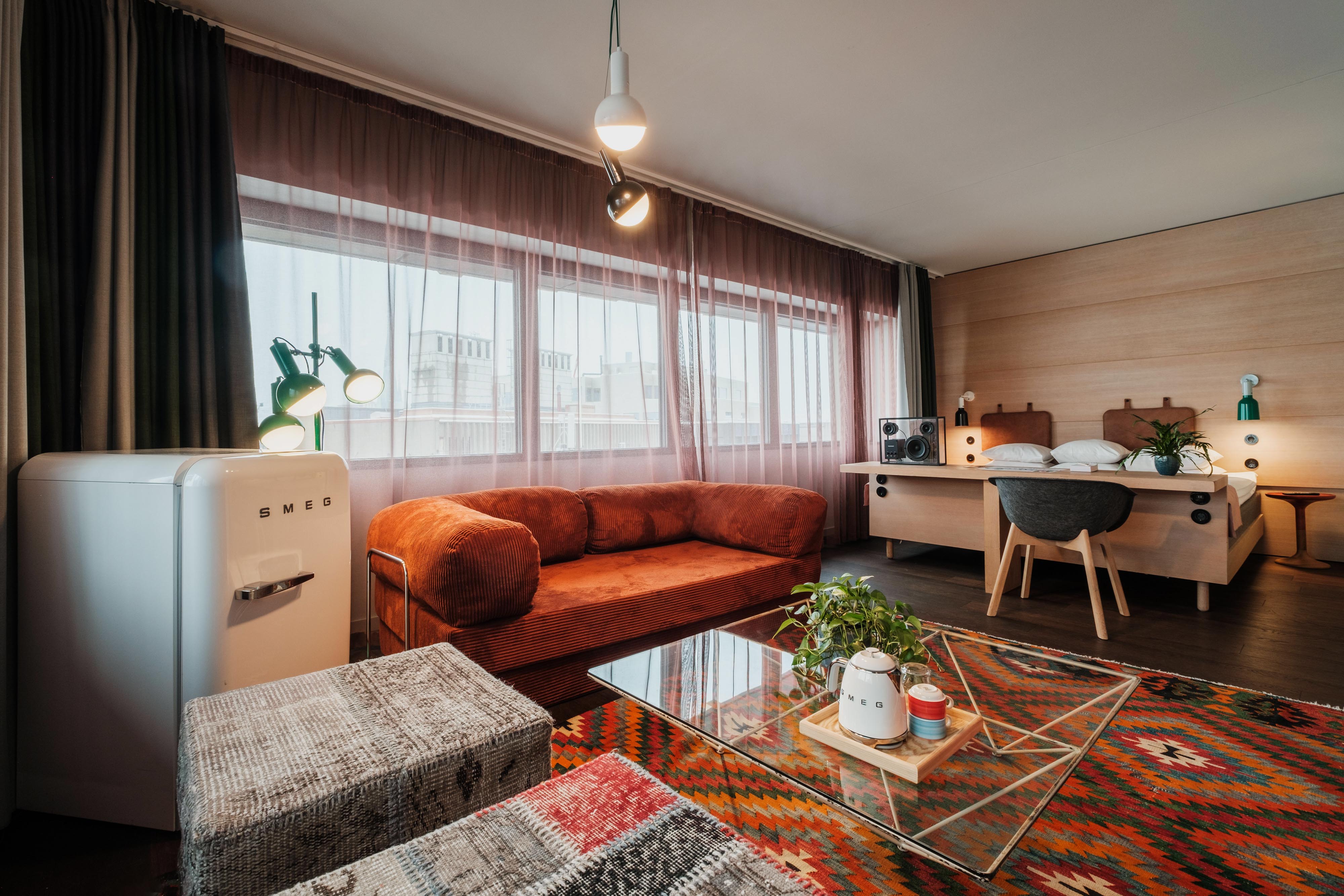 Suite at Hotel Hobo in Stockholm with king size bed, spacious lounge area, light wood desk and designer speaker.