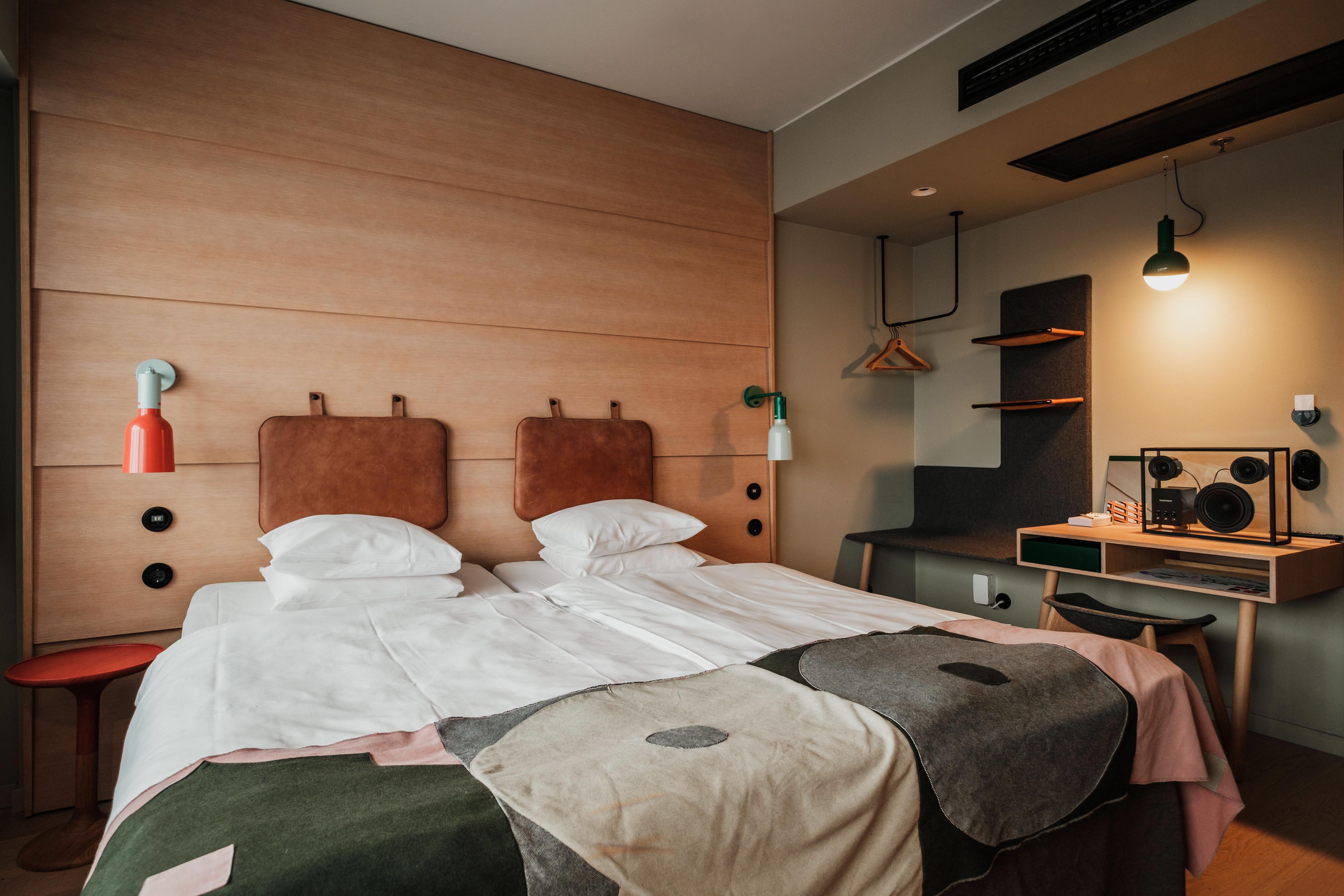 Superiorrum på Hobo Hotel i centrala Stockholm med två enkelsängar, skrivbord i ljust trä med tillhörande stol och en designhögtalare.