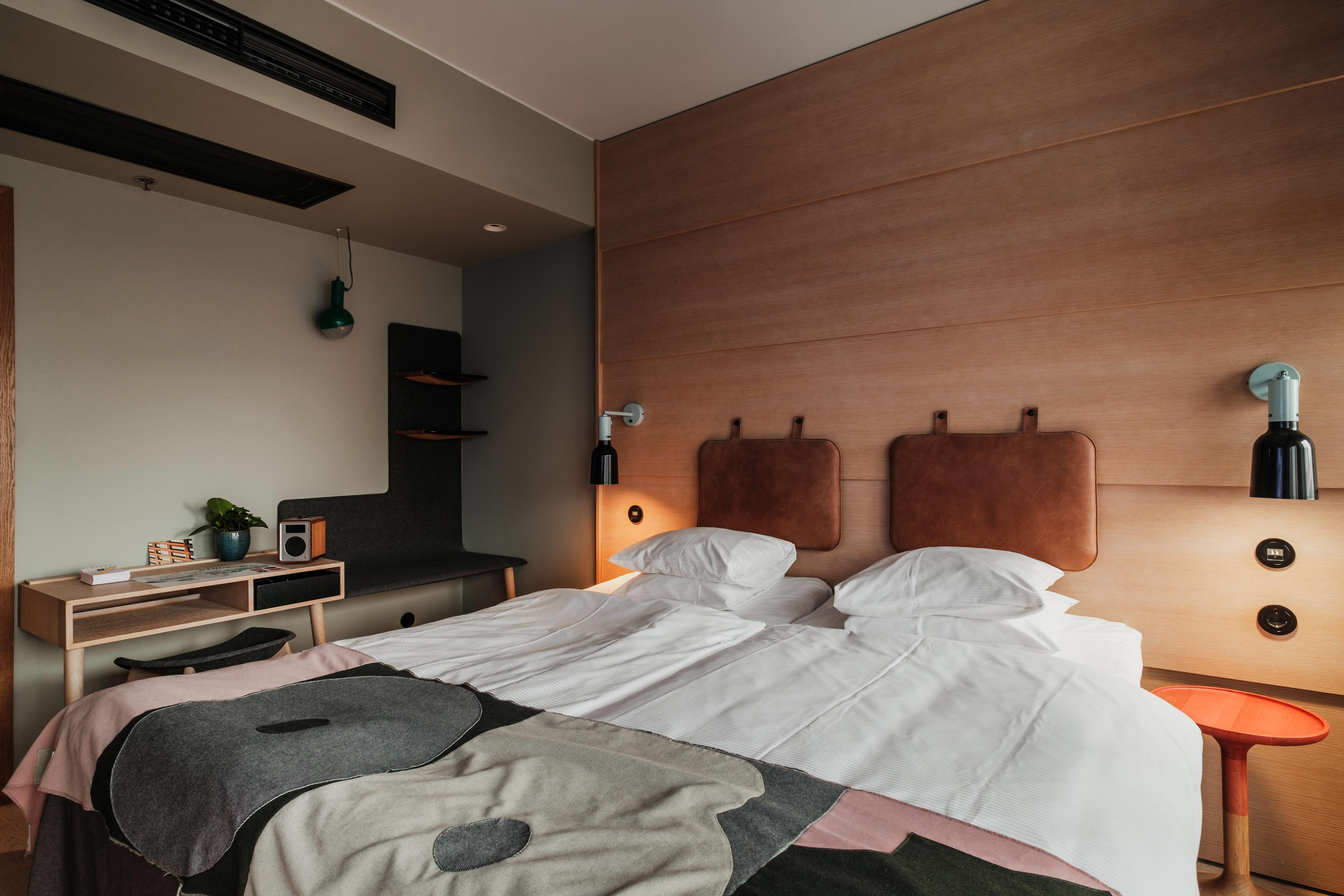 The Standard Room at Hobo Hotel in Stockholm features modern details and creative interior design, with a light wood desk and matching chair.