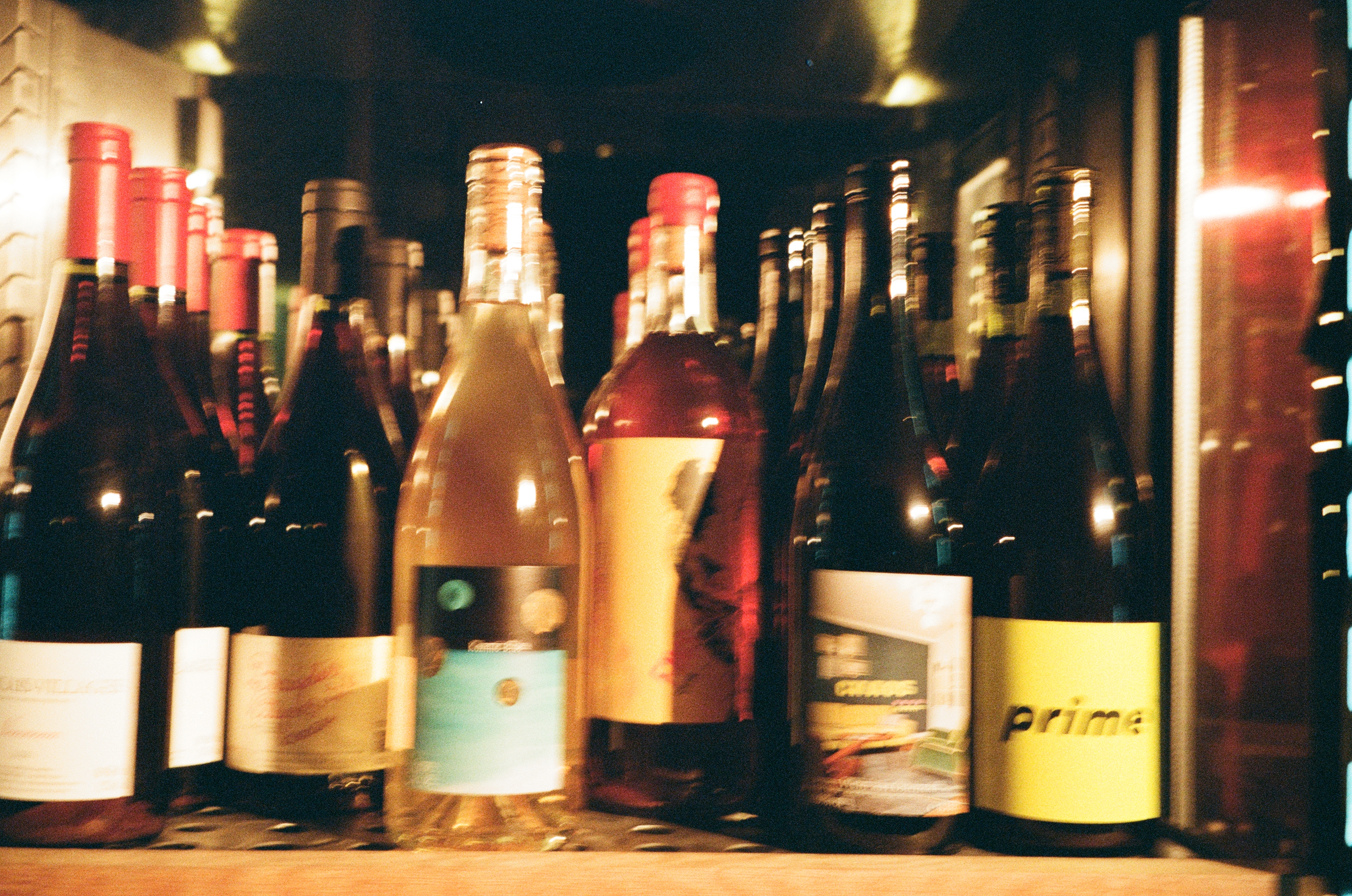 Blurrig bild på flera fina naturvinsflaskor i olika färger och former i baren på Hobo Hotel i centrala Stockholm.