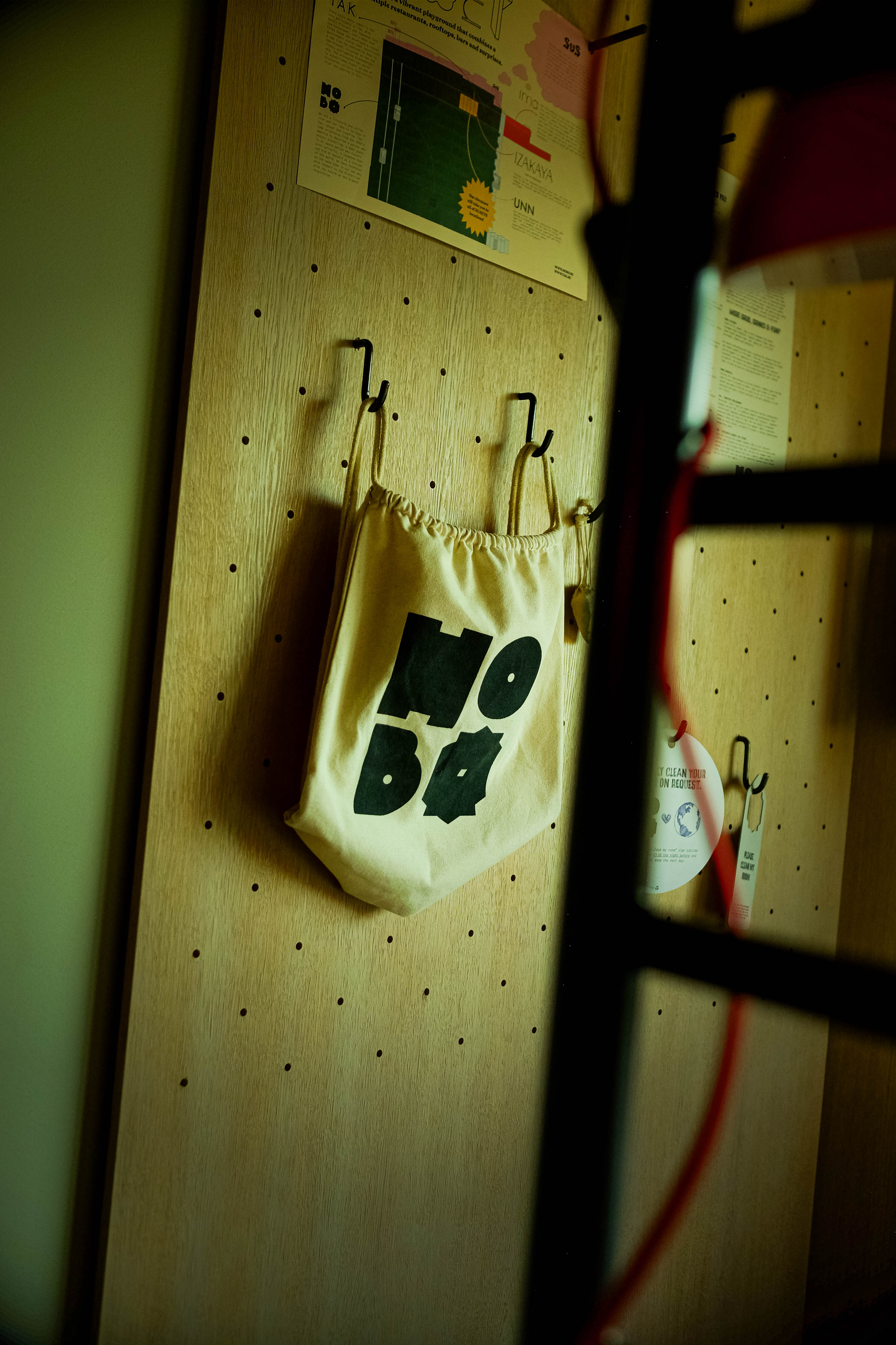 White Hobo backpack with a large Hobo logo hanging on a peg wall in a hotel room at Hobo Hotel in central Stockholm.