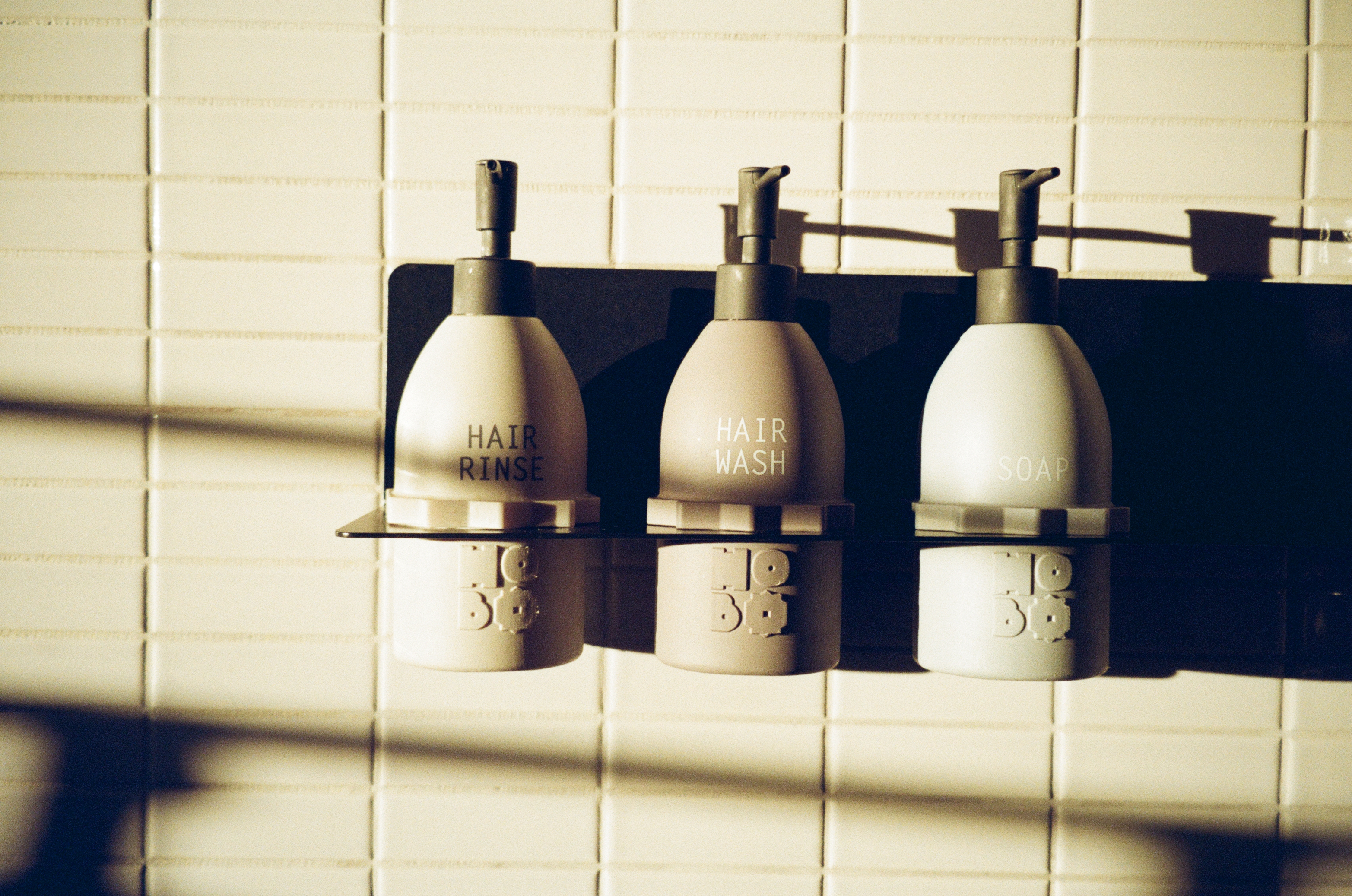 Analog photo of hair rinse, shampoo, and soap in the shower of a hotel room at Hobo Hotel in central Stockholm.