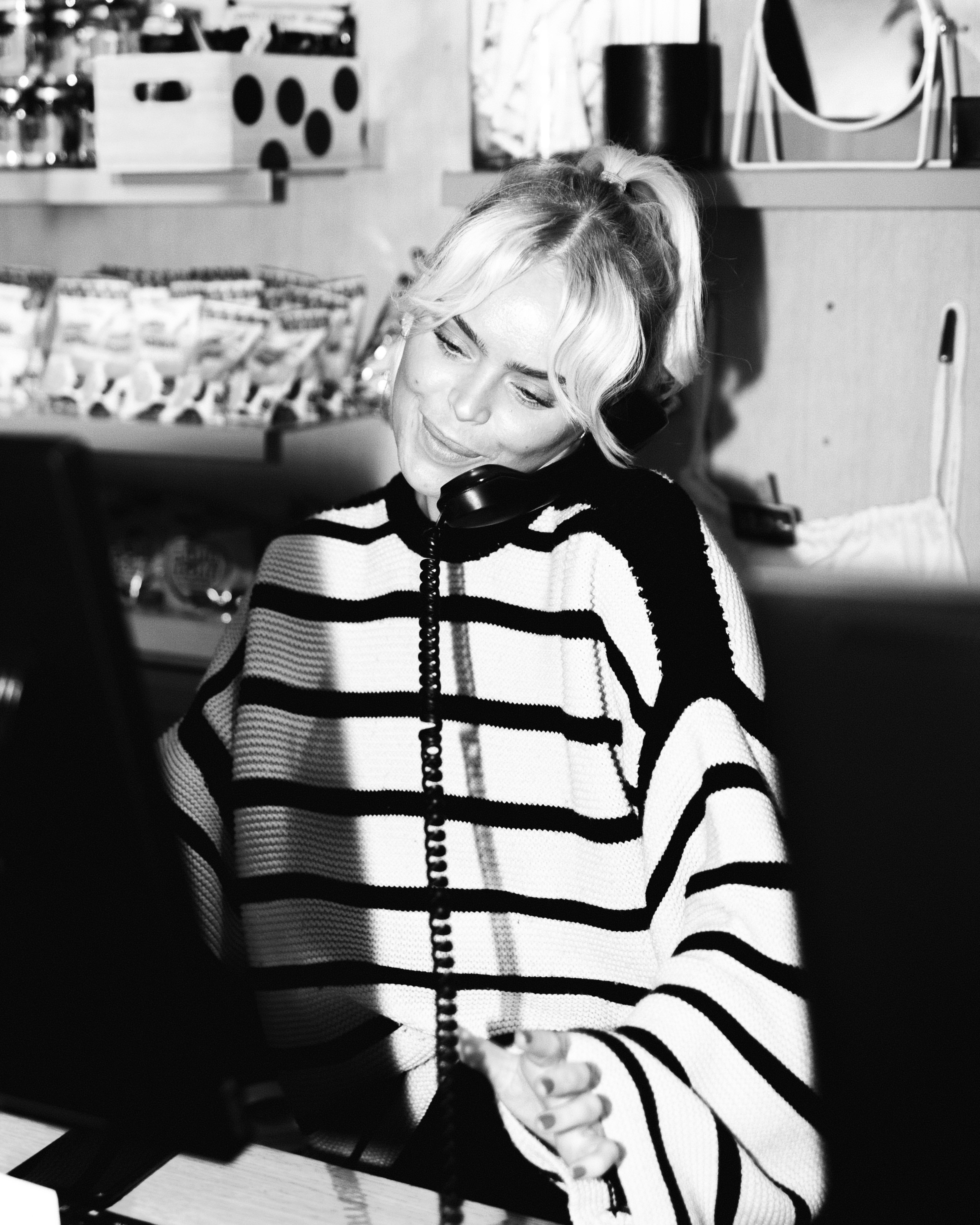Black and white photo of a receptionist talking on the phone at Hobo Hotel in central Stockholm.
